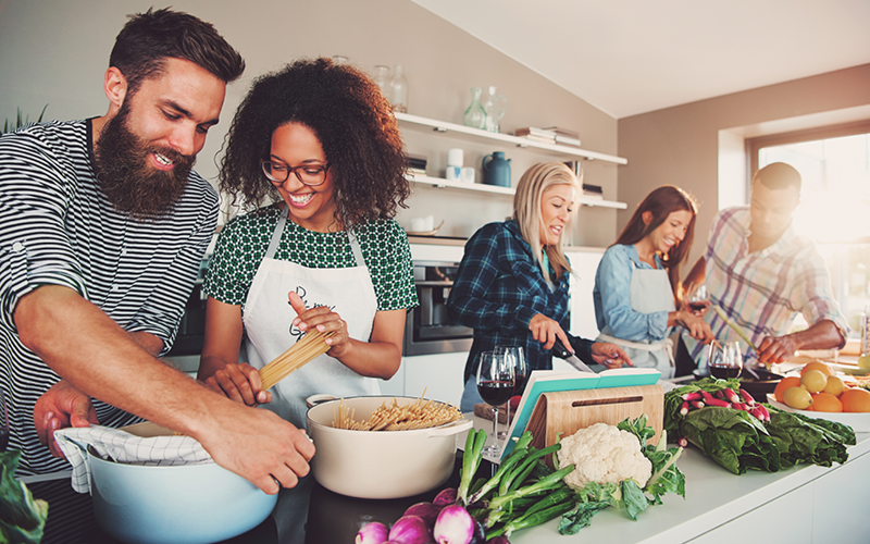 Friends in the kitchen prep a sustainable and nutrition meal together.