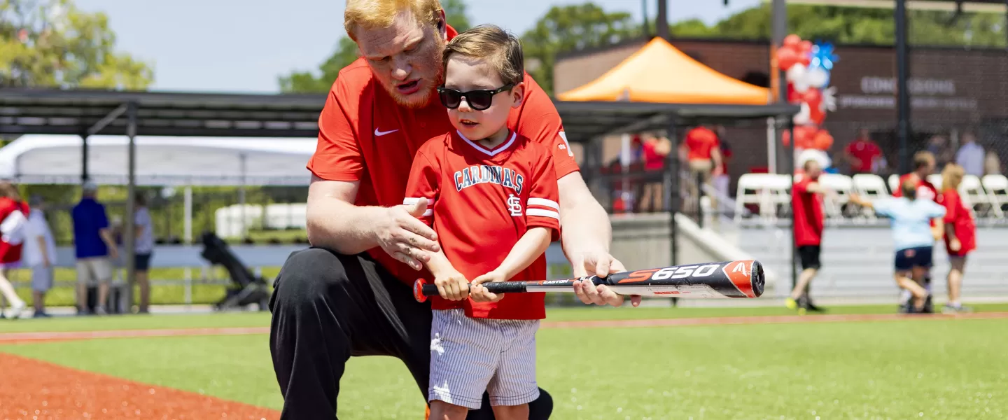 ymca adaptive baseball participant and volunteer on adaptive sports complex field