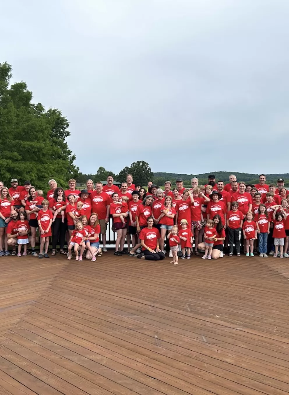 Family reunion posing for a group photo on the Trout Lodge deck in front of Sunnen Lake