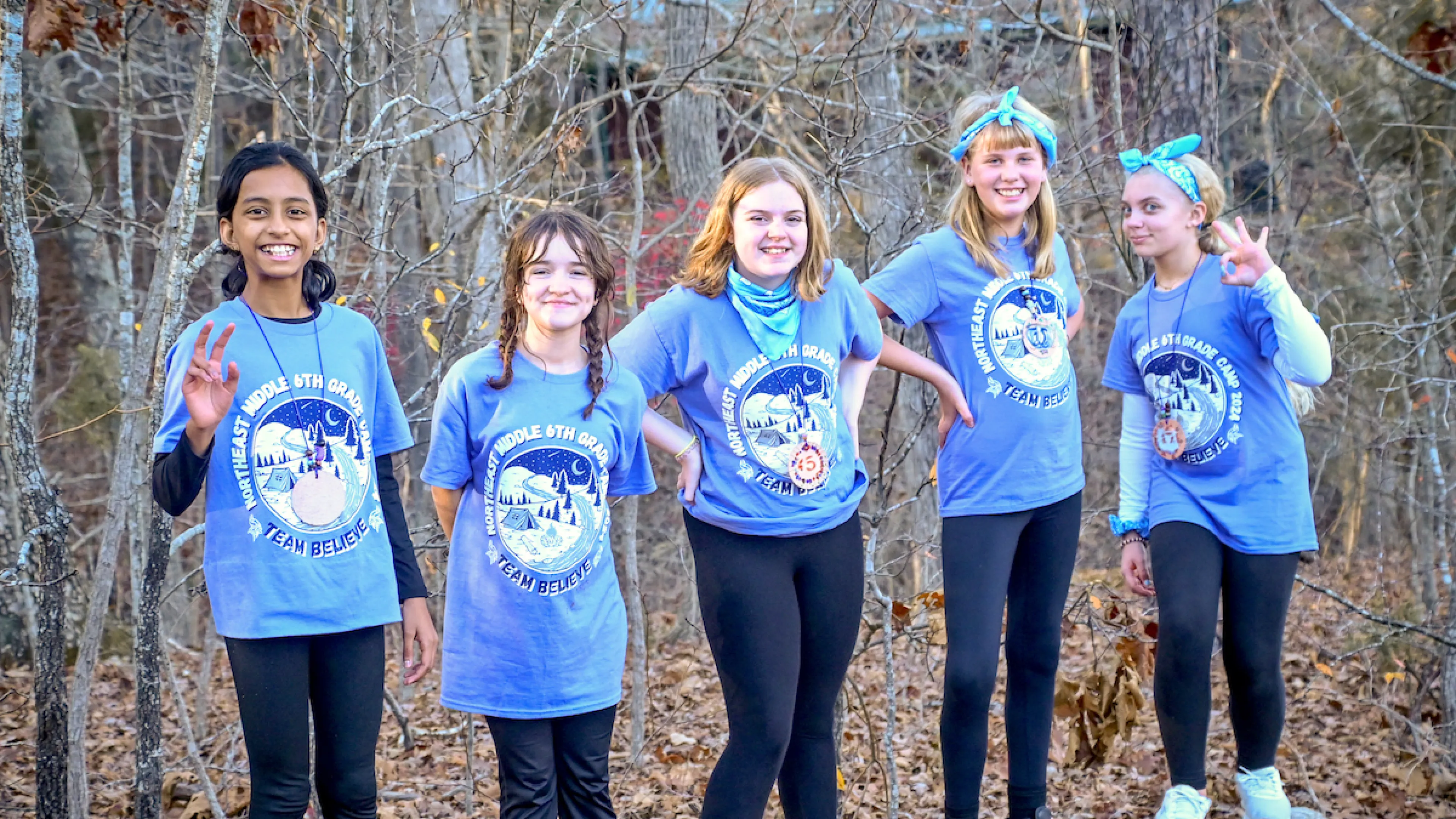 Group of smiling students posing together outdoors during Outdoor Education camp