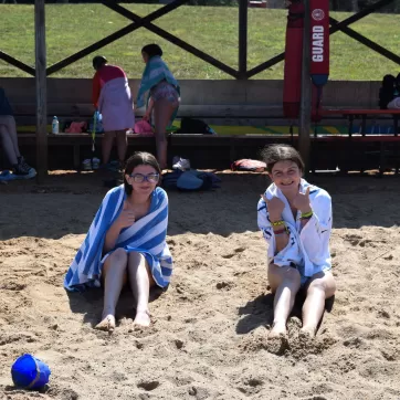 two ymca camp lakewood campers sitting on shore of lake