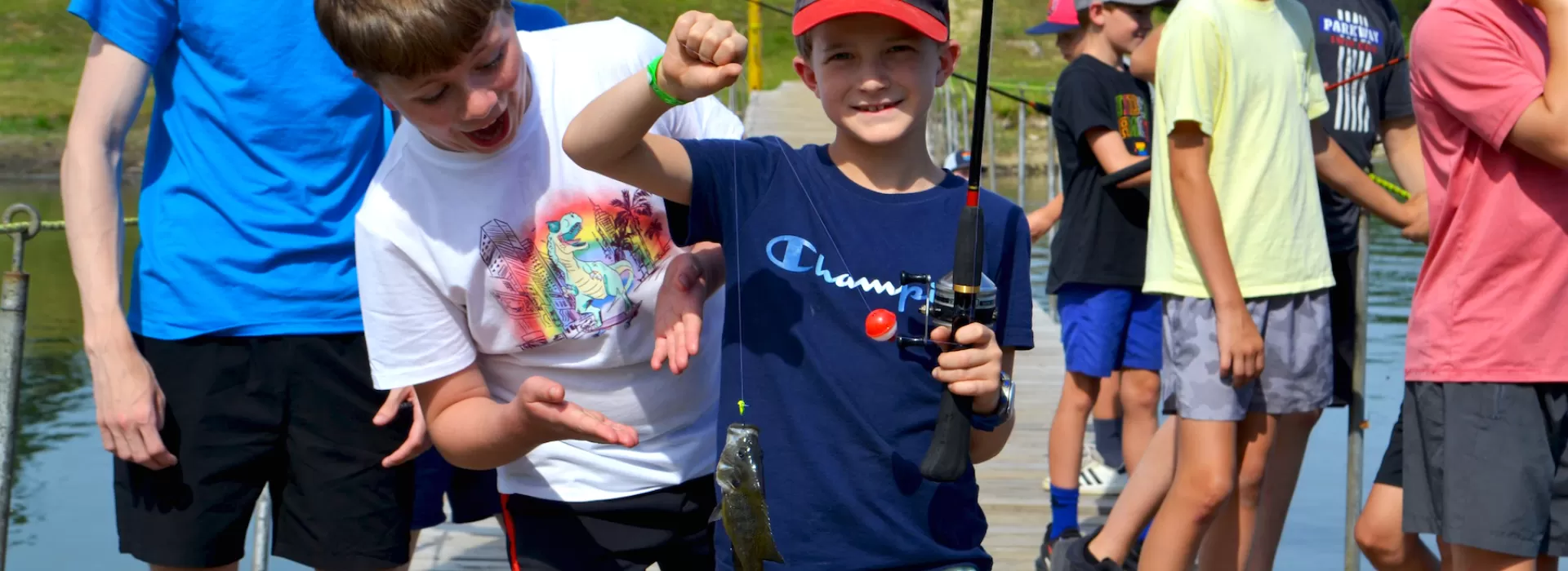 ymca camp lakewood boy fishing with a fish he caught